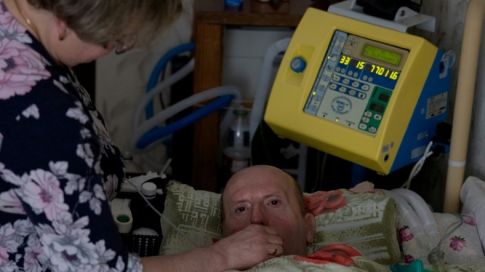 Ukrainian wife battles blackouts to keep terminally ill husband alive